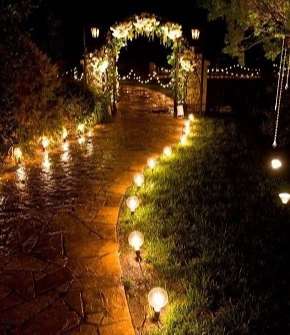 camino de entrada a casapor la noche iluminado con lamparas.