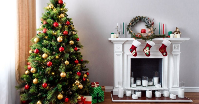 Salón con decoración navideña como son; el árbol de navidad y los calcetines de papa noel en la chimenea 